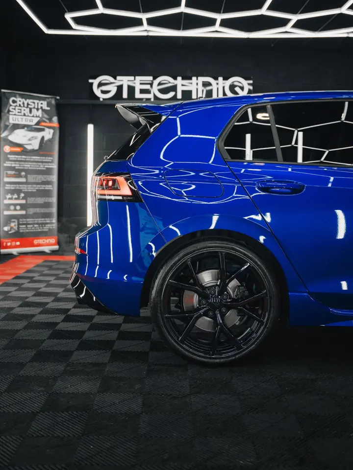 Blue Volkswagen Golf R rear quarter beside the Gtechniq sign